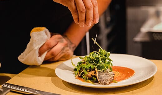 Cuisinier qui assaisonne un plat